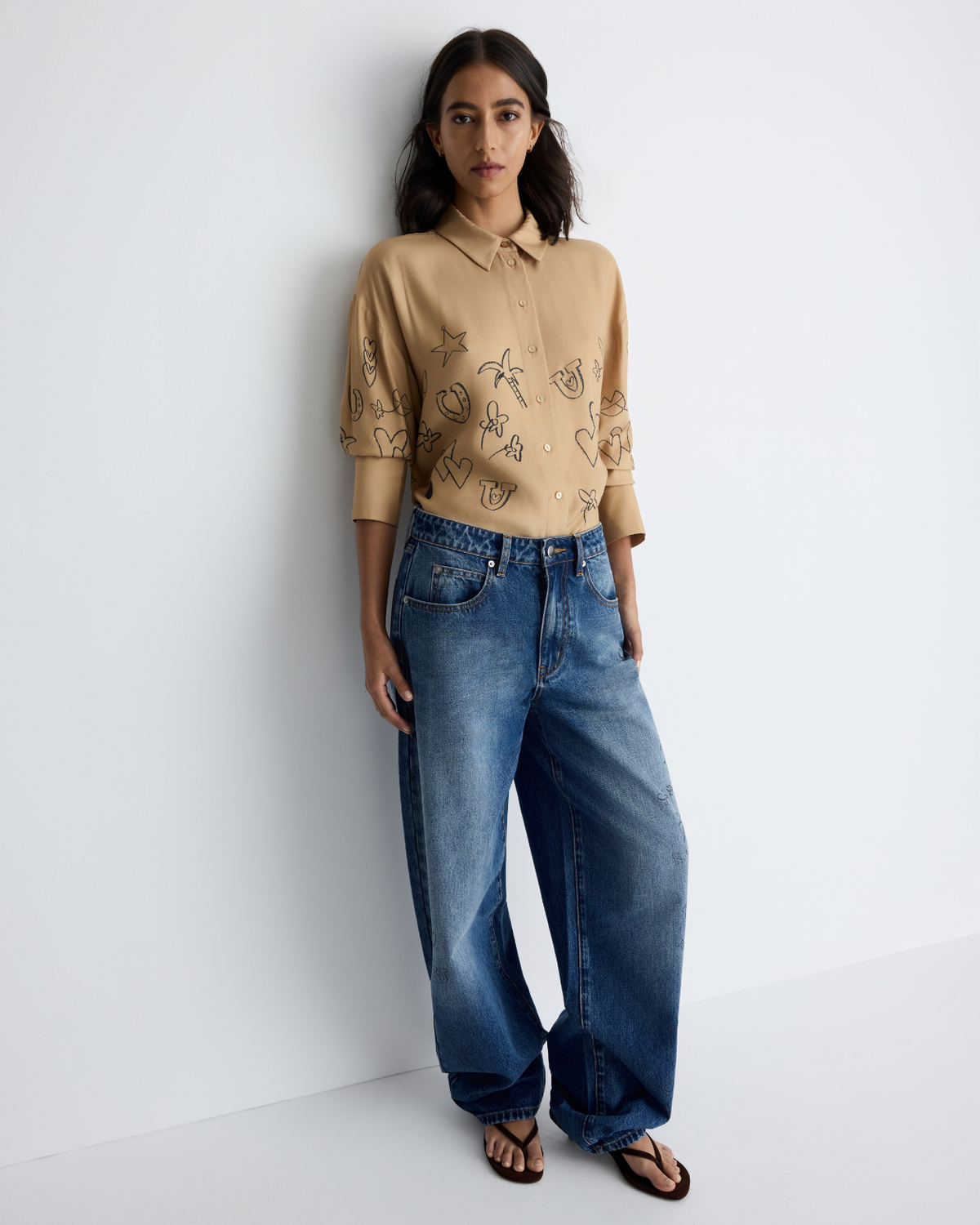 Jakey Shirt in sand with artwork, styled with jeans, three-quarter view on model.