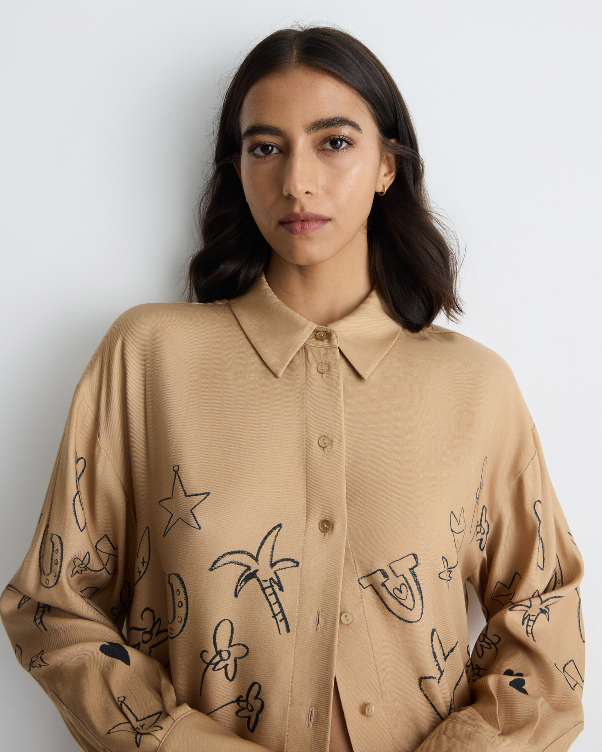 Jakey Shirt in sand with artwork, close-up on model.