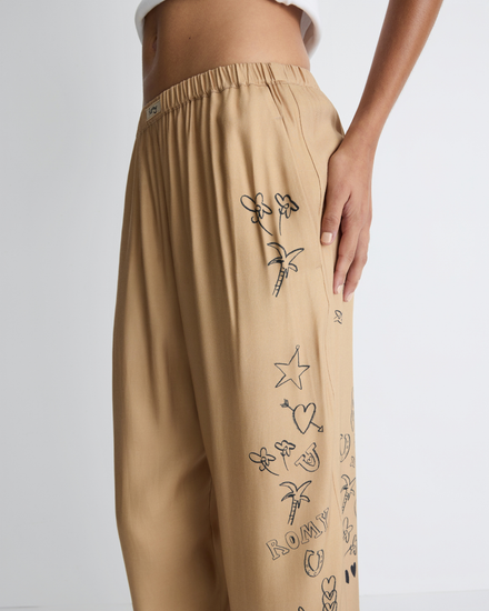 Jakey Pant in sand with artwork, waist and artwork detail on model.