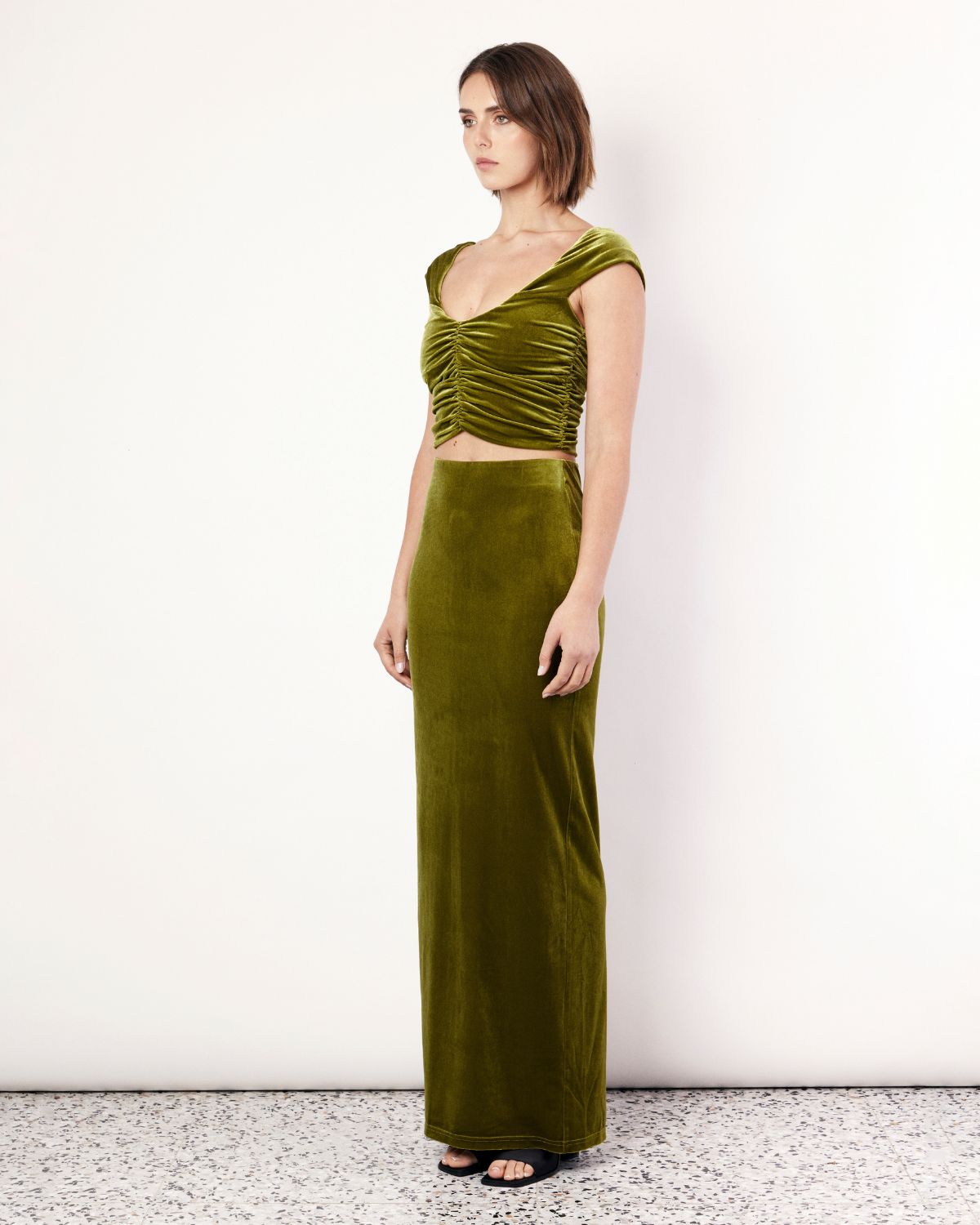 The Velvet Maxi Skirt is a figure hugging silhouette that falls to an elegant maxi length. It has an elastic waistband and is crafted from a plush stretch Velvet fabrication in a stunning green hue. Now available at Romy. 