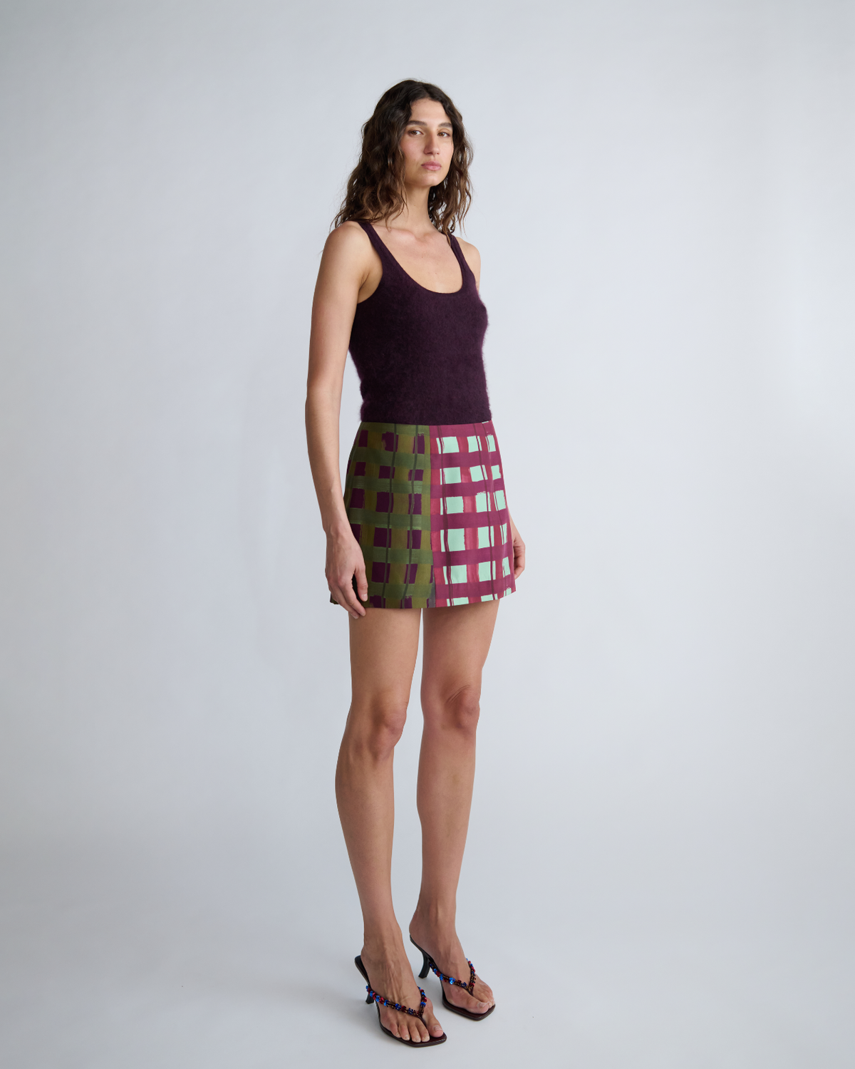 Three-quarter view of the ROMY Ardent Skirt showing its structured mini silhouette and bold geometric check print.