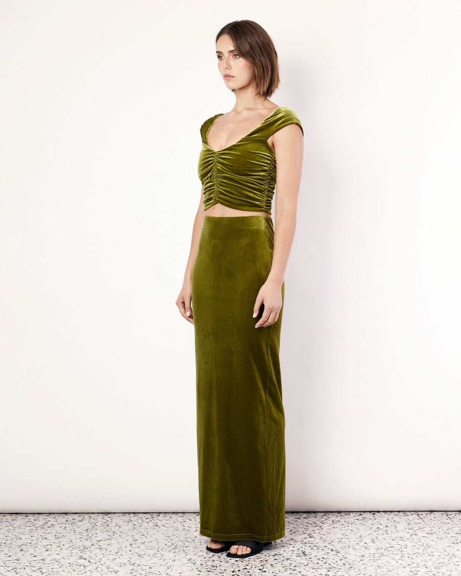 The Velvet Top exudes elegance and lust featuring ruched detailing, an off the shoulder neckline, and a cropped length. It is crafted from a plush stretch Velvet fabrication in a stunning green hue. Now available at Romy. 