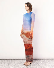 The Sunset Vista Long Sleeve Maxi Dress is a striking dress adorned with the exclusive Romy Sunset Vista print. Featuring double-layered mesh through the body, this dress boasts a breathtaking blend of warm hues that evoke the tranquillity of a setting sun. Crafted with long sleeves for added elegance and versatility, it features a flattering silhouette that gently cascades to the floor. Now available to shop at Romy. 