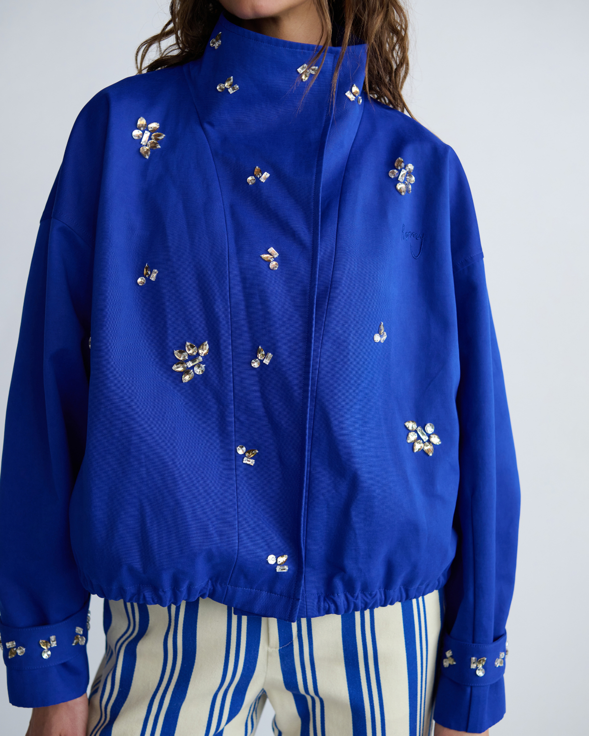 Close-up of the cobalt blue Cropped Forever Jacket featuring hand-beaded floral embellishments and gathered hem.