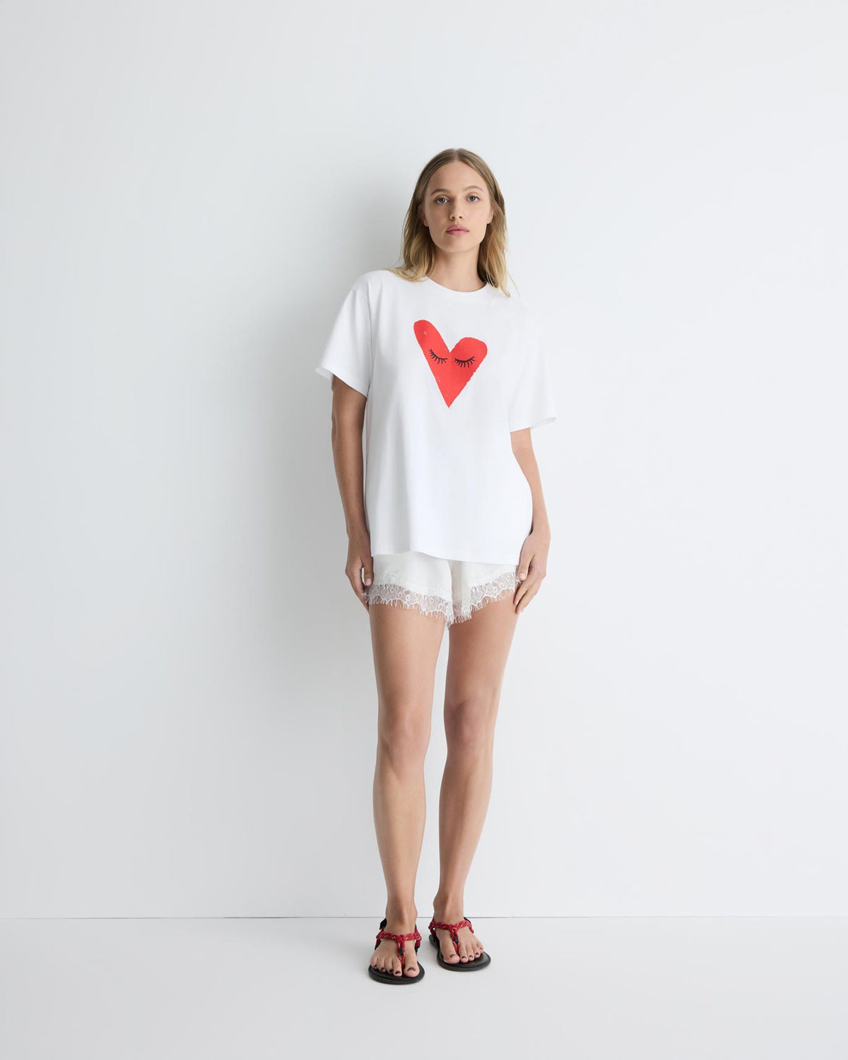 Kiss My Eyes To Sleep Tee in white with red heart, front view on model.