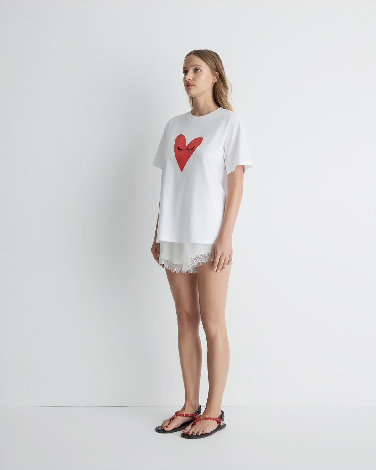 Kiss My Eyes To Sleep Tee in white with red heart, three-quarter view on model.