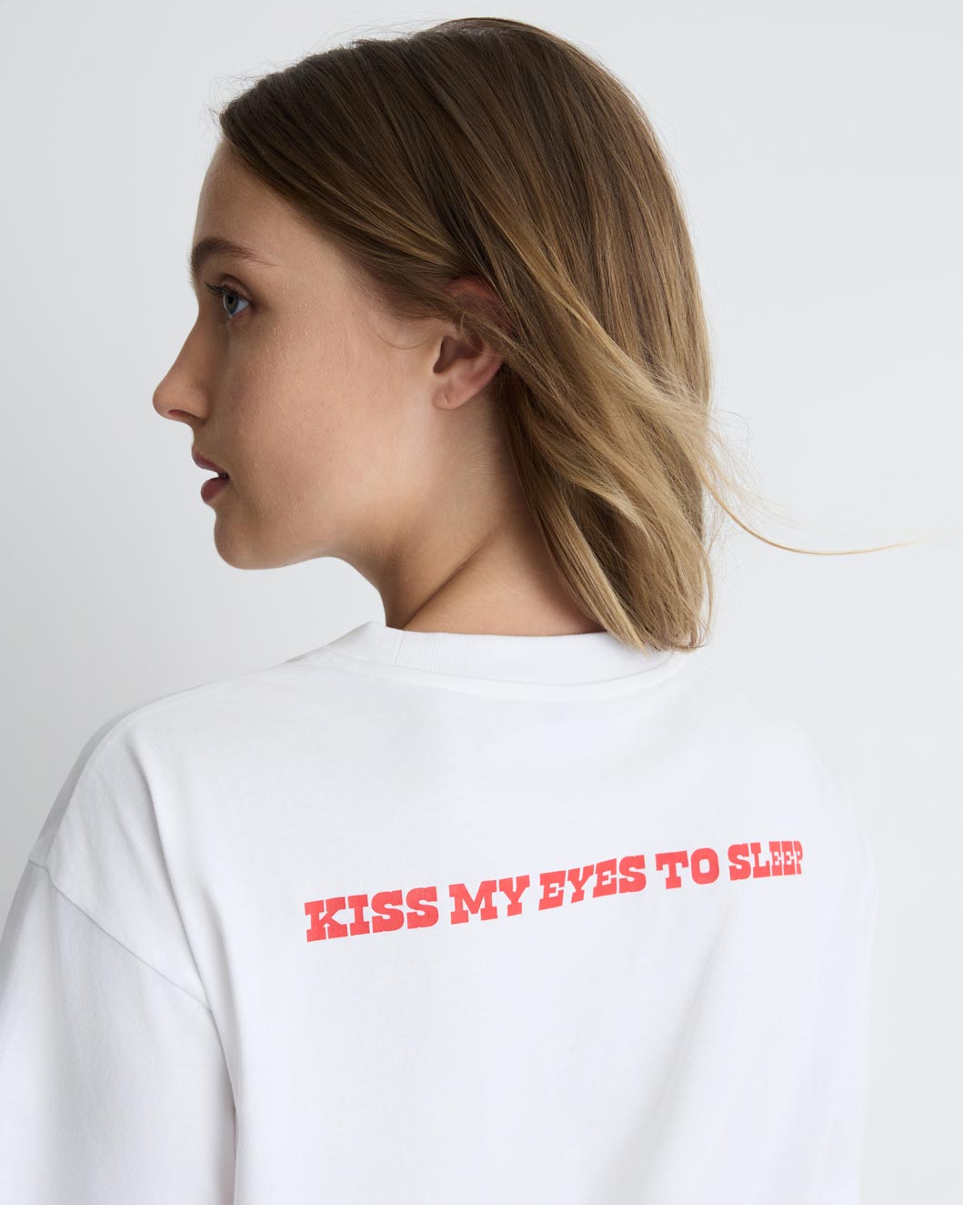 Kiss My Eyes To Sleep Tee in white with red heart, back close-up on model.