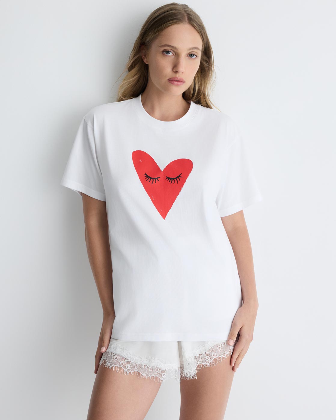 Kiss My Eyes To Sleep Tee in white with red heart, front close-up on model.