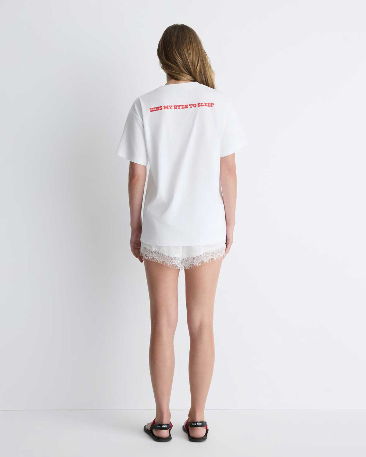 Kiss My Eyes To Sleep Tee in white with red heart, back view on model.
