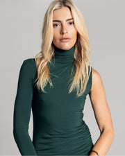 The One Sleeve Maxi Dress takes a twist on classic elegance, featuring one exposed arm and a funnel neck. It is crafted from a soft Oeko-Tex® Certified Bamboo Spandex Jersey and is double lined, perfect to hug you in, in a deep Emerald Green hue. Now available at Romy. 