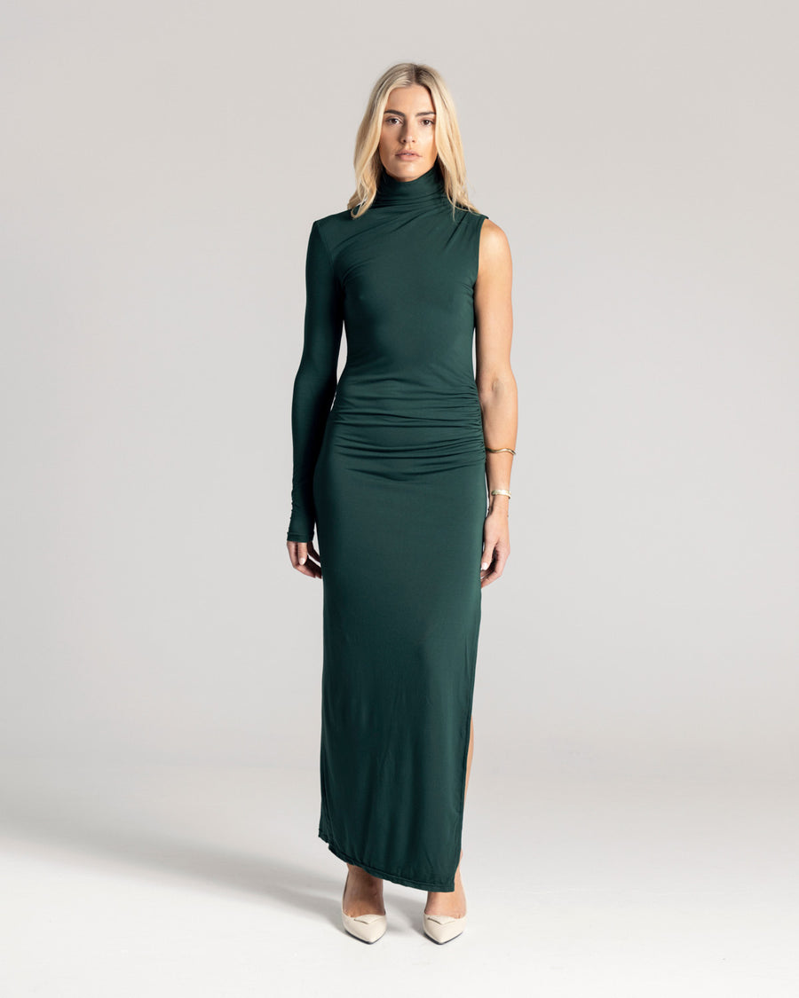 The One Sleeve Maxi Dress takes a twist on classic elegance, featuring one exposed arm and a funnel neck. It is crafted from a soft Oeko-Tex® Certified Bamboo Spandex Jersey and is double lined, perfect to hug you in, in a deep Emerald Green hue. Now available at Romy. 
