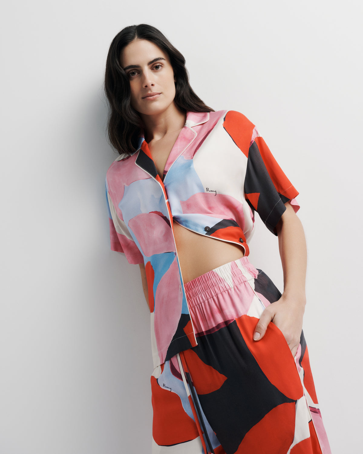 Reese Shirt in pink, red and black abstract print, styled close-up with the June Pant.