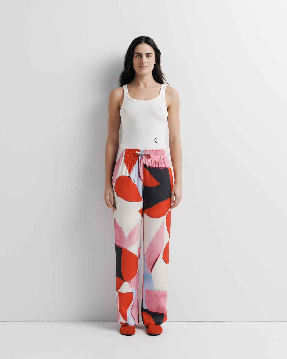 June Pant in pink, red and black abstract print, front view on model.
