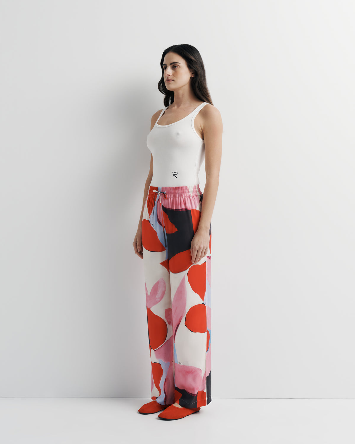 June Pant in pink, red and black abstract print, three-quarter view on model.