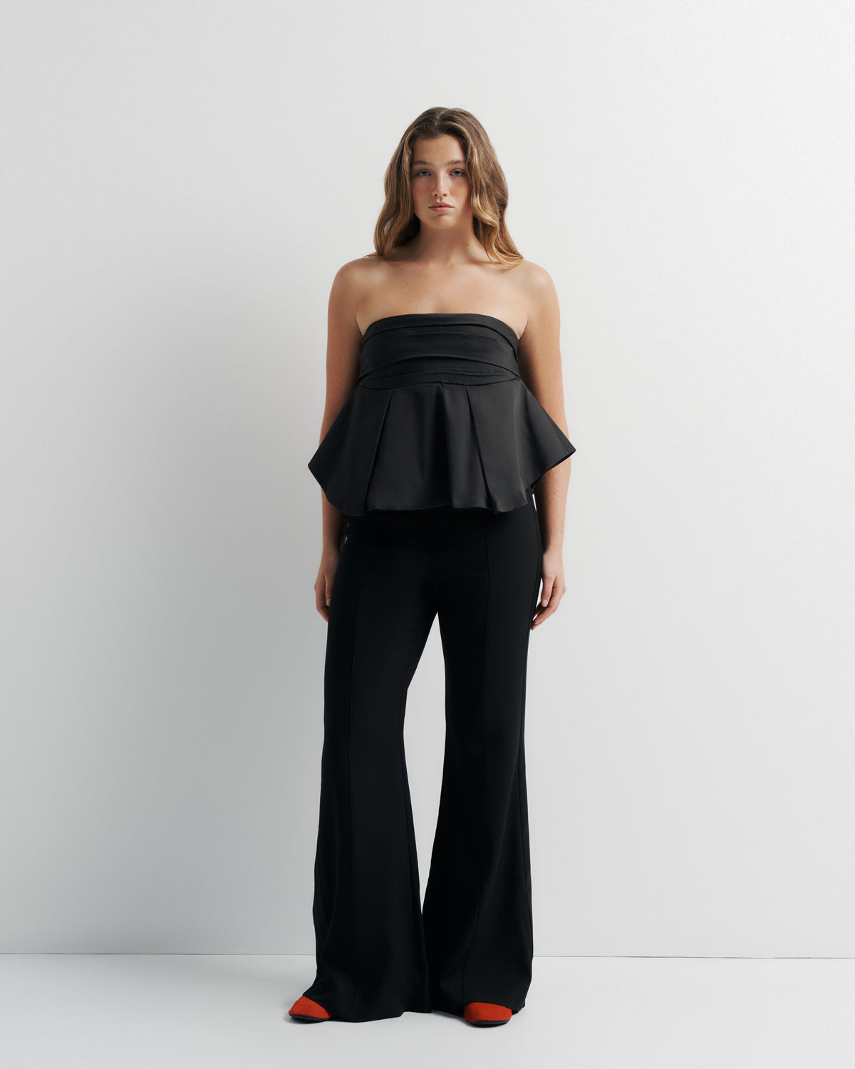 Bella Bustier in black, styled with black trousers, front view on model.