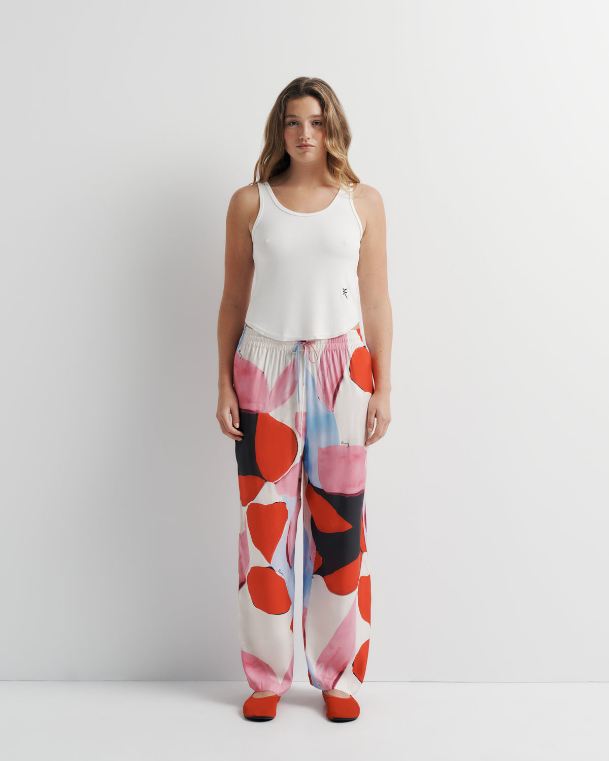 June Pant in pink, red and black abstract print, front view on model, second look.