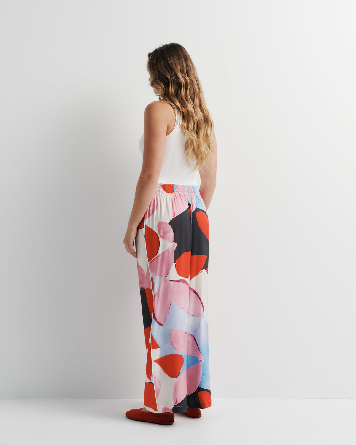 June Pant in pink, red and black abstract print, back view on model, second look.