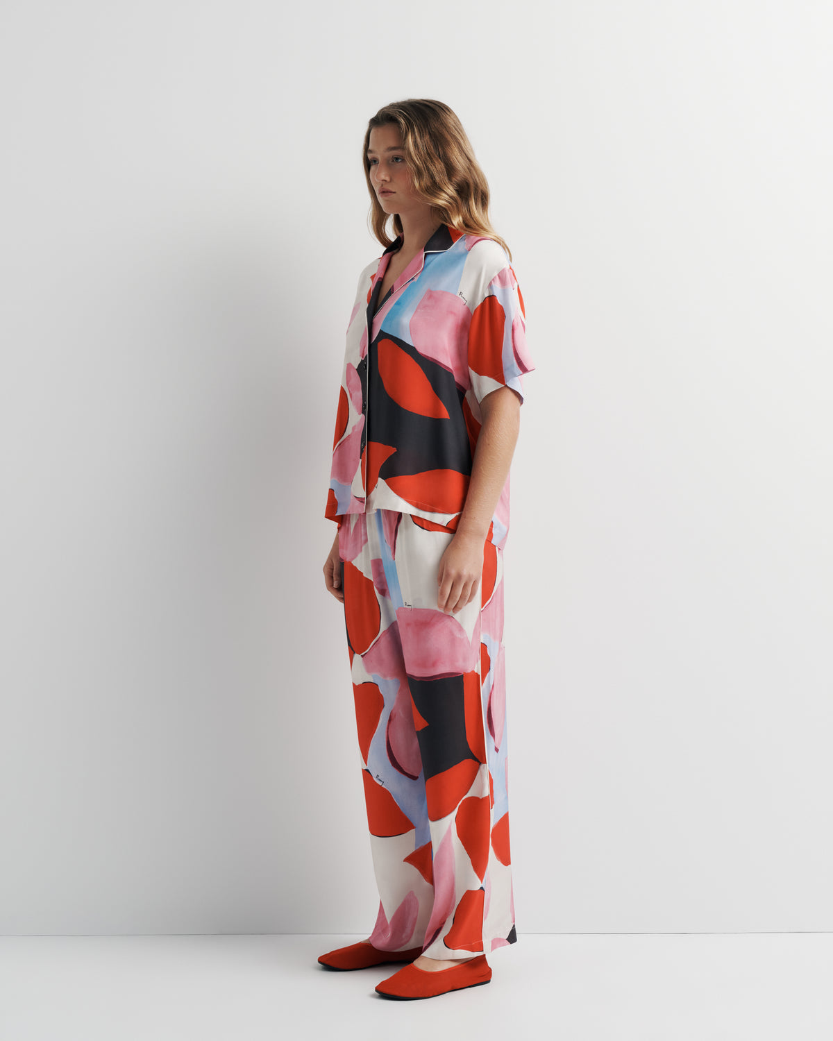 Reese Shirt in pink, red and black abstract print, three-quarter view on model.