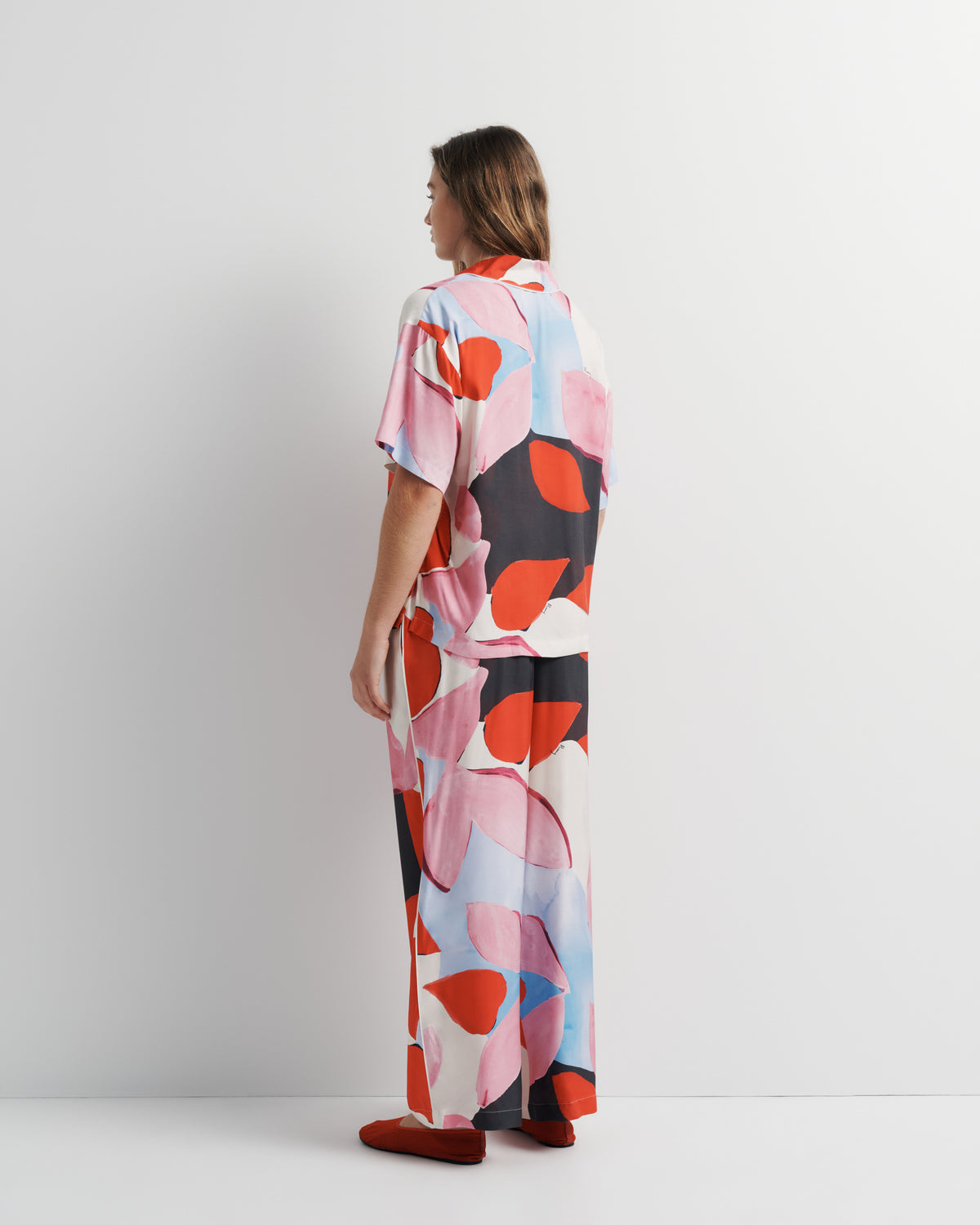 Reese Shirt in pink, red and black abstract print, side view on model.