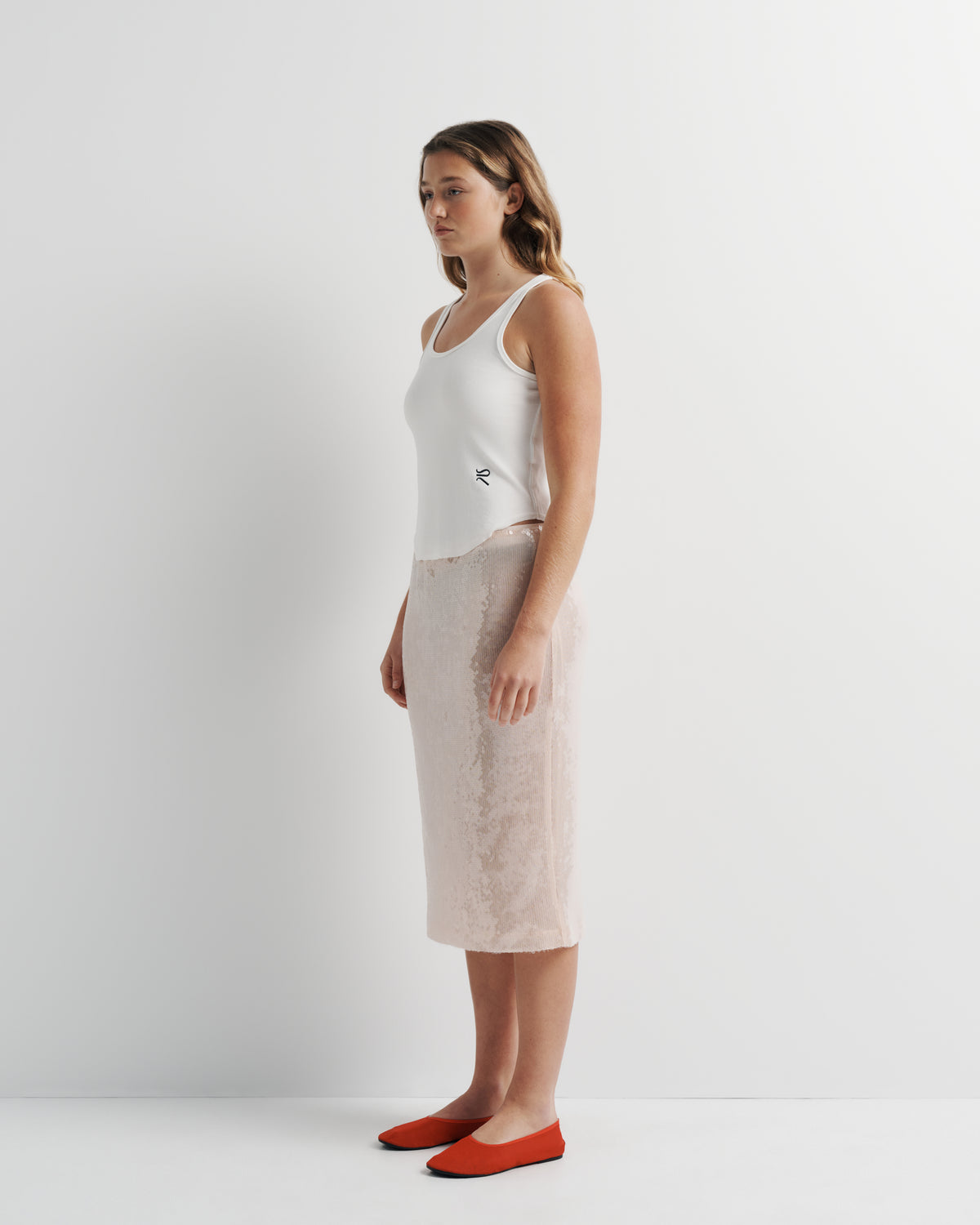 Janey Midi Skirt in pink sequin with polyester mesh lining, side view on model.