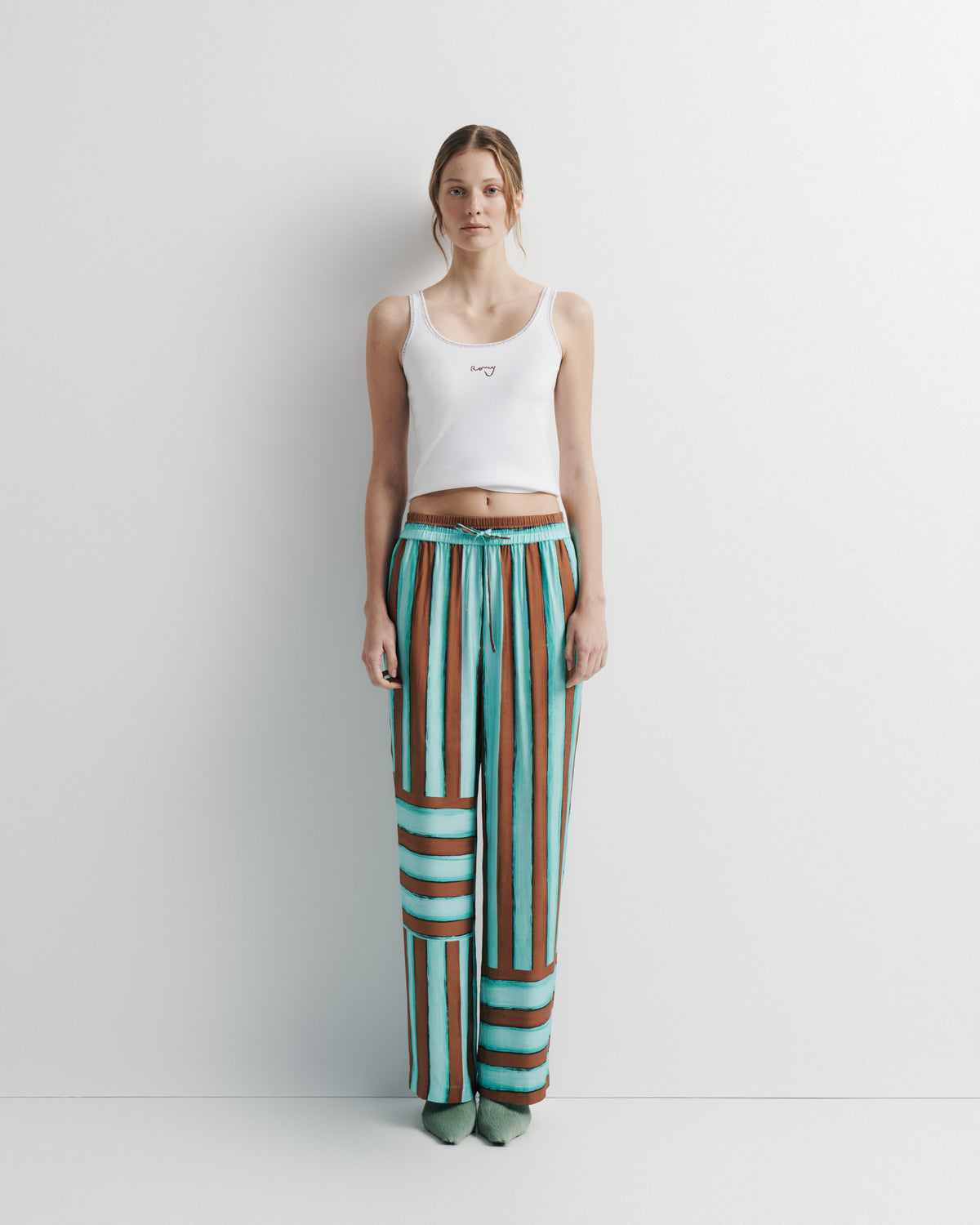 June Pant in aqua and rust hand-painted print, front view on model.