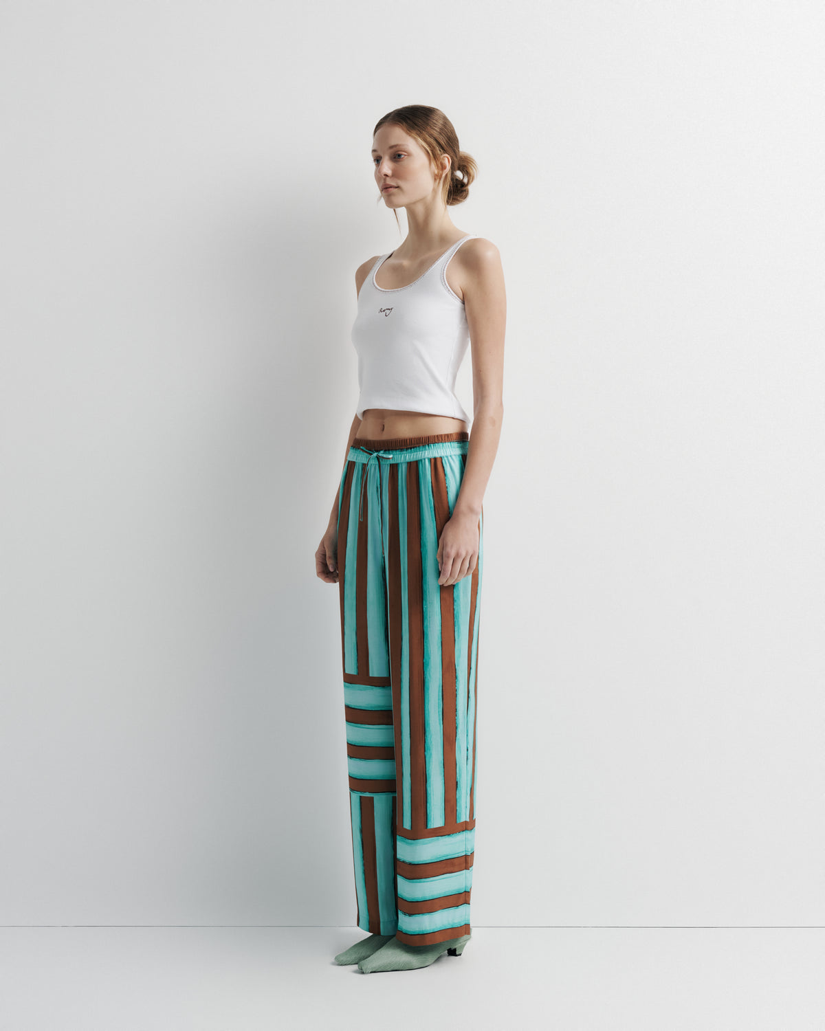 June Pant in aqua and rust hand-painted print, three-quarter view on model.