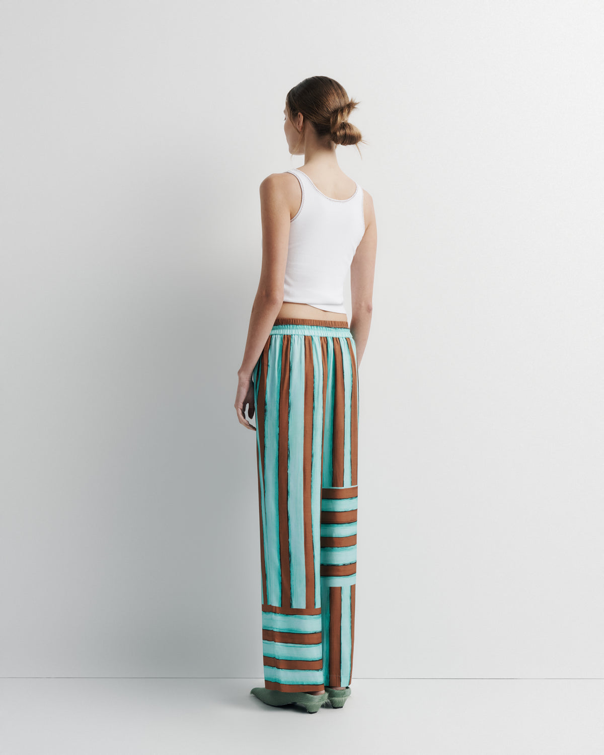 June Pant in aqua and rust hand-painted print, back view on model.