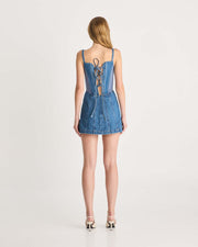 This mini length denim dress features a specially designed lace up corset detail on the back, scooped neckline, scuba panels through the side waist and a lightweight denim fabric to keep you comfortable all day. Perfect for any summer party. Shop now.