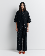 The June Shirt is an oversized short sleeve button-up featuring a concealed placket, exaggerated sleeves, and delicate floral embroidery for a subtle romantic touch. Pair it with the matching pant or wear it open over a tank for easy styling. Shop now.