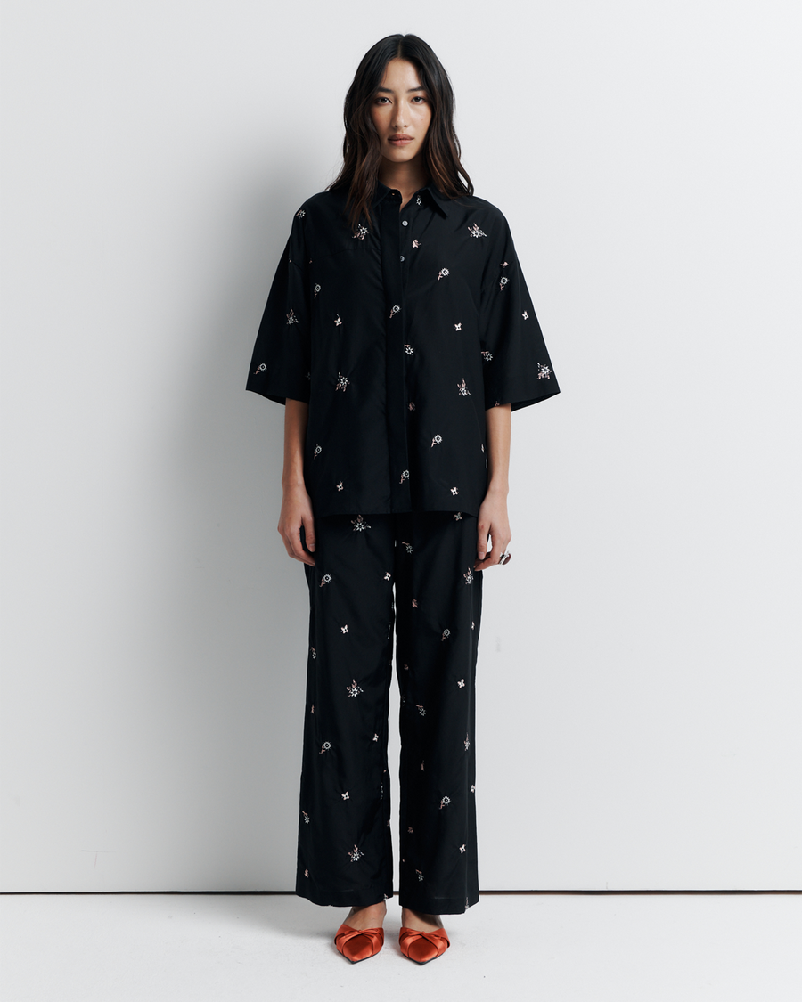 The June Shirt is an oversized short sleeve button-up featuring a concealed placket, exaggerated sleeves, and delicate floral embroidery for a subtle romantic touch. Pair it with the matching pant or wear it open over a tank for easy styling. Shop now.