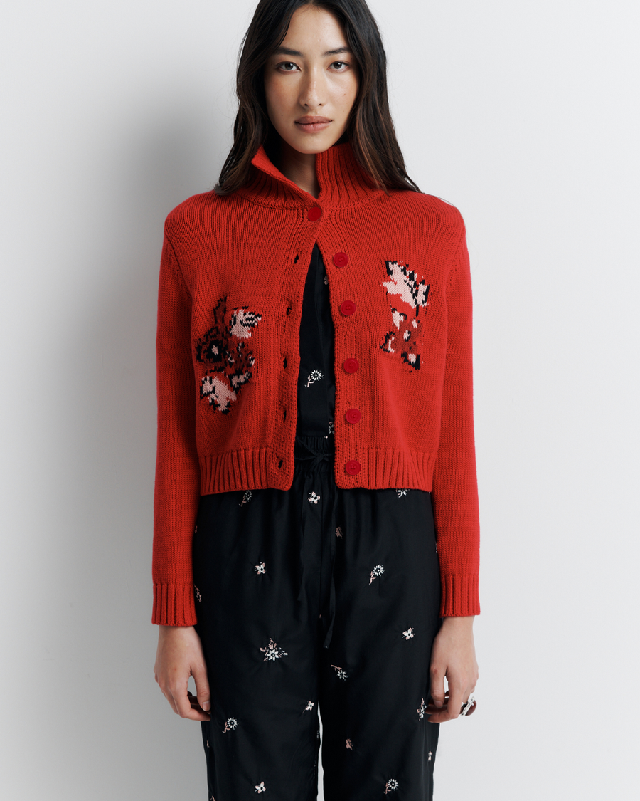 The Lara Cardigan is a fitted, collared knit featuring delicate floral motifs and a timeless button-front design—perfect for layering with a touch of vintage charm.