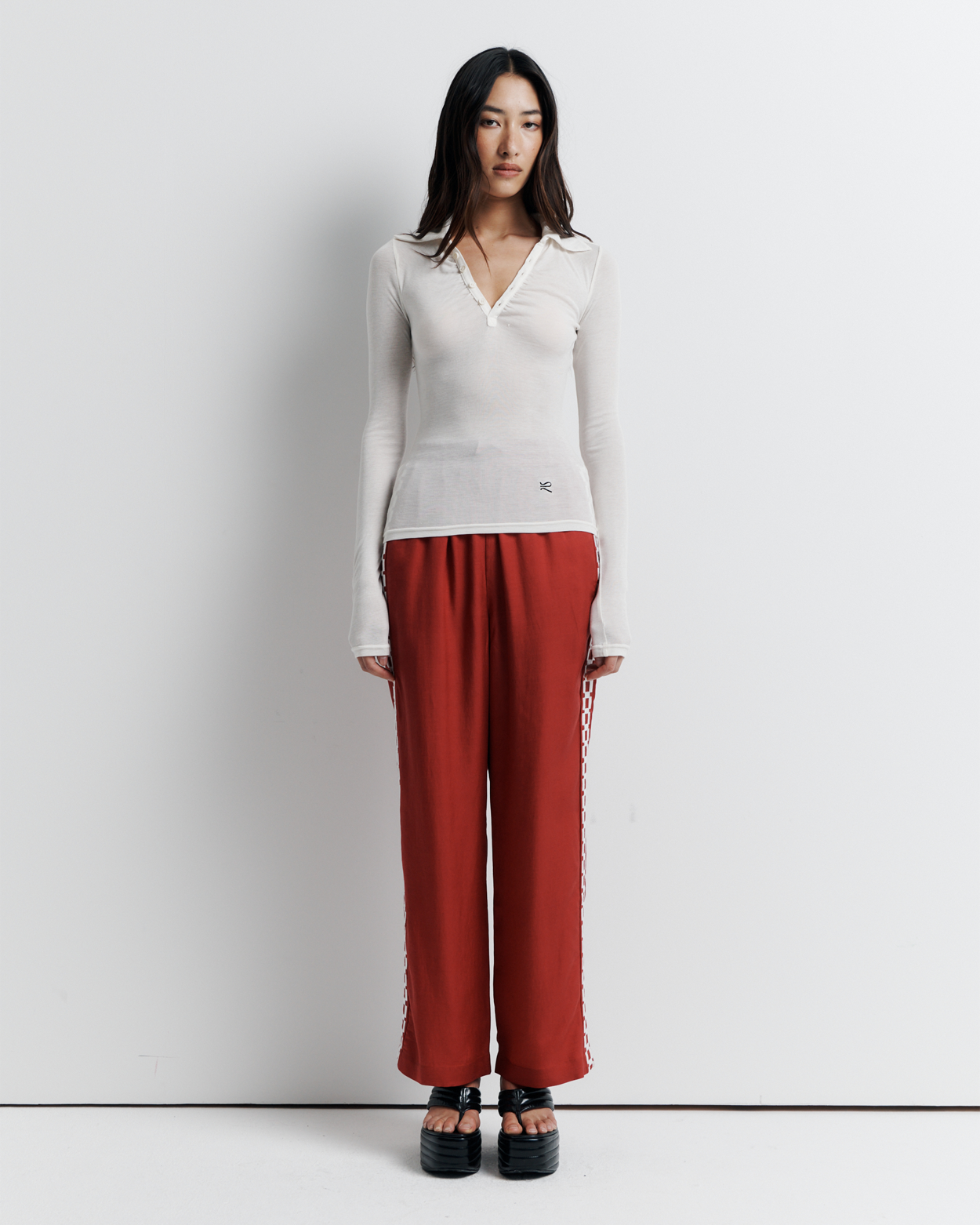 The Louise Knit Top in White is a collared Henley-style knit featuring soft bust gathers, elongated sleeves for layering, and signature ‘R’ embroidery—an effortlessly polished wardrobe essential.