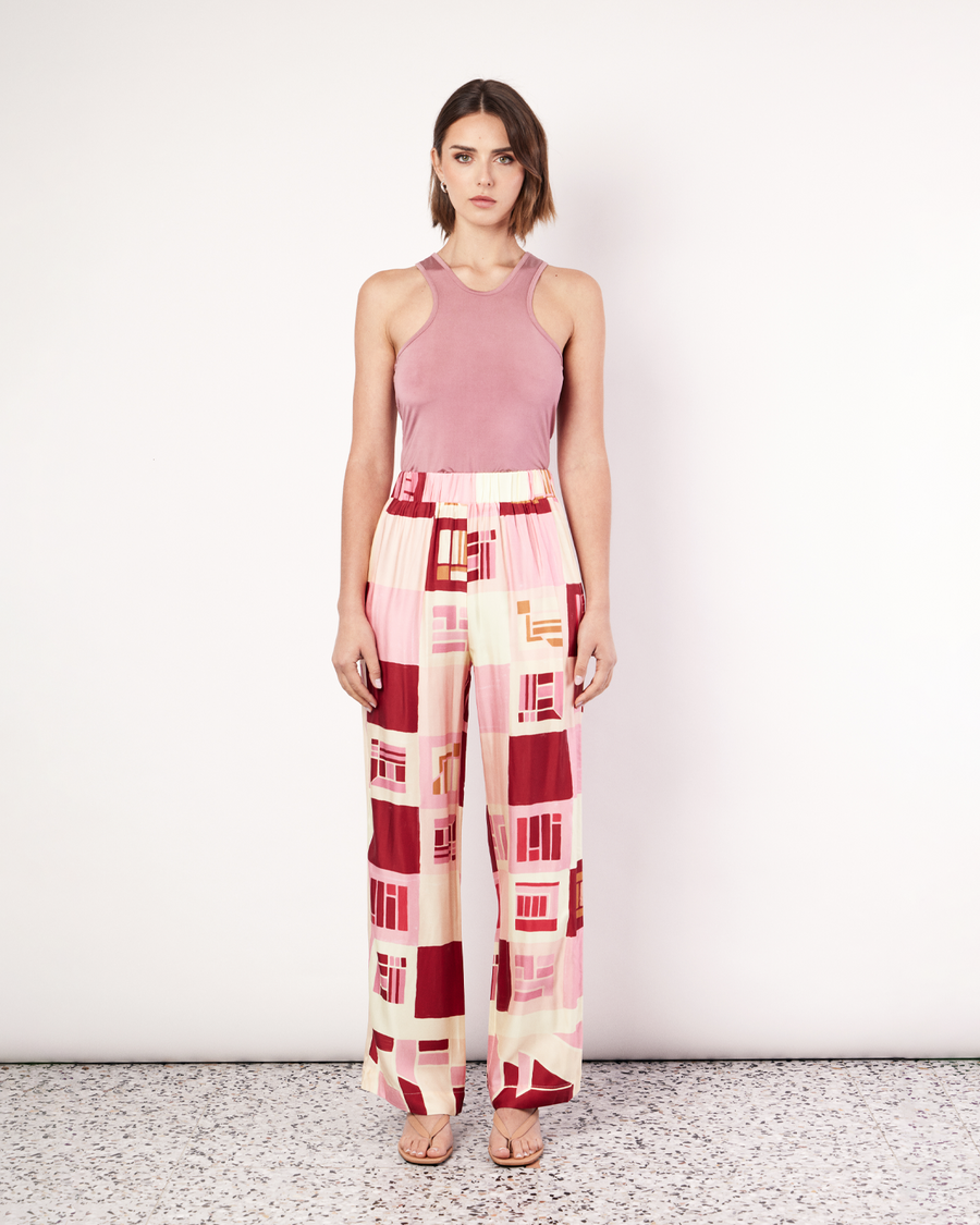 The Retro Pant is a relaxed straight leg pant featuring an elastic waistband and side pockets. It is crafted from a silky recycled Oeko-Tex® certified viscose in the Resort 24' retro-inspired print. By Romy, now available. 