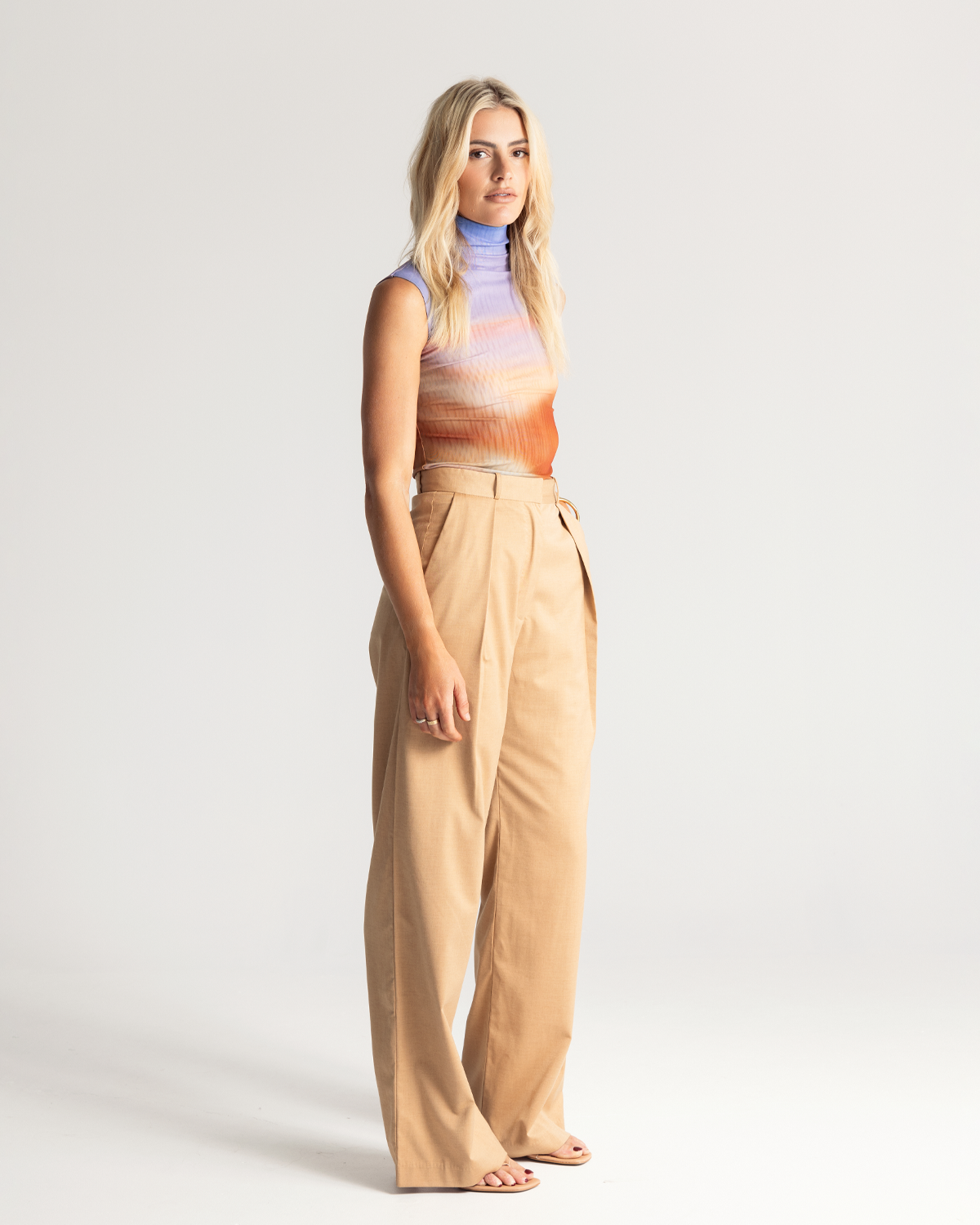 The Pleat Front Pant are an easy-wearing wide leg pant featuring a hidden clasp closure, pockets, and pleated detailing down the front, creating a subtle drape in the leg. They are crafted from a soft wool blend in Tan. Now available at Romy. 
