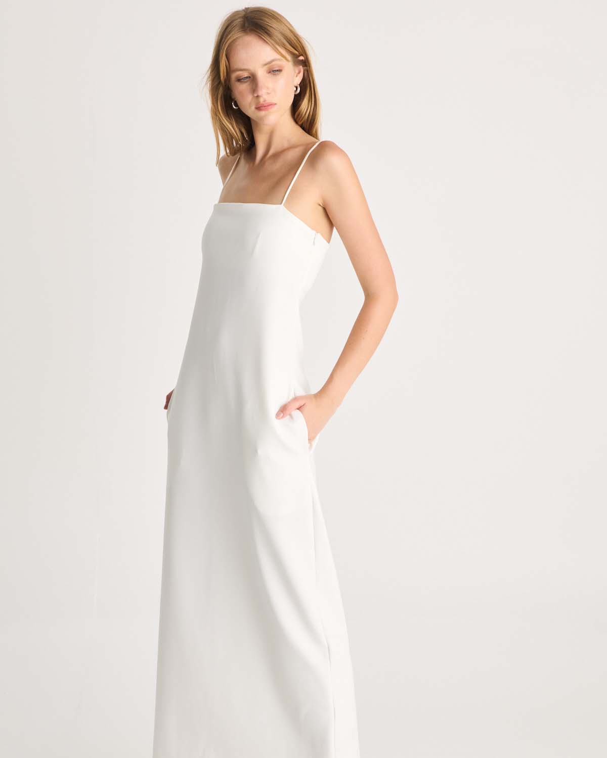 This floor-length bandeau dress is designed in our signature Romy scuba fabric. It features side pockets, delicate rouleau shoulder straps and an inner shelf bra provide both support and an elevated look. This white maxi dress is destined to become your essential wardrobe piece. Available exclusively at Romy and The Iconic. Show now.