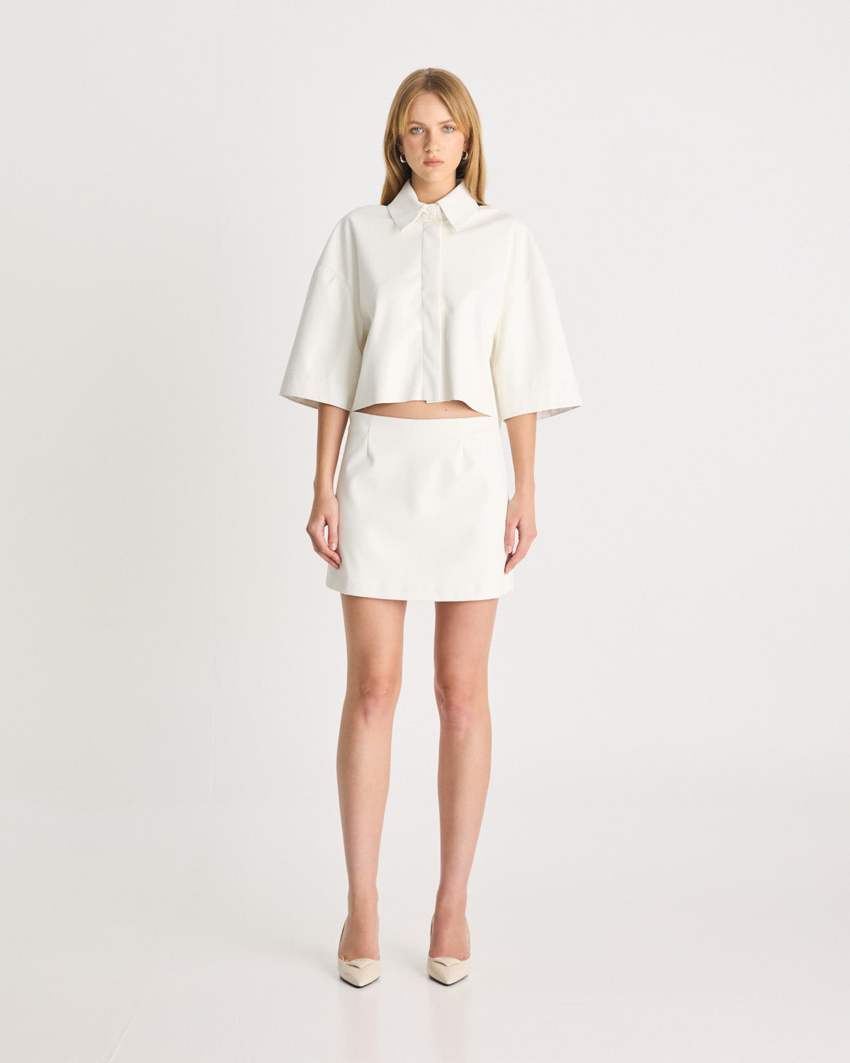 The Vegan Leather Mini Skirt is an elevated silhouette, designed to sit low-mid rise on the hips. Tailored from vegan leather in a bright white, offering a structured, straight fit. Shop online at Romy now with Afterpay and free express shipping available.