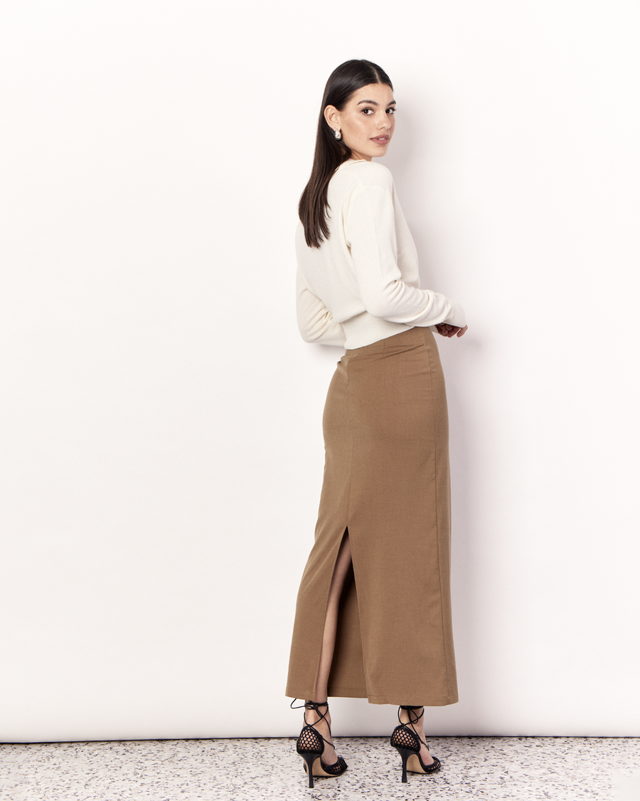 The Cropped Collared Sweater is a trans-seasonal knitwear essential, featuring a collar, deep-v neckline, and cropped hem. It is crafted from a luxurious Wool Cashmere blend in Cream. Now available at Romy. 