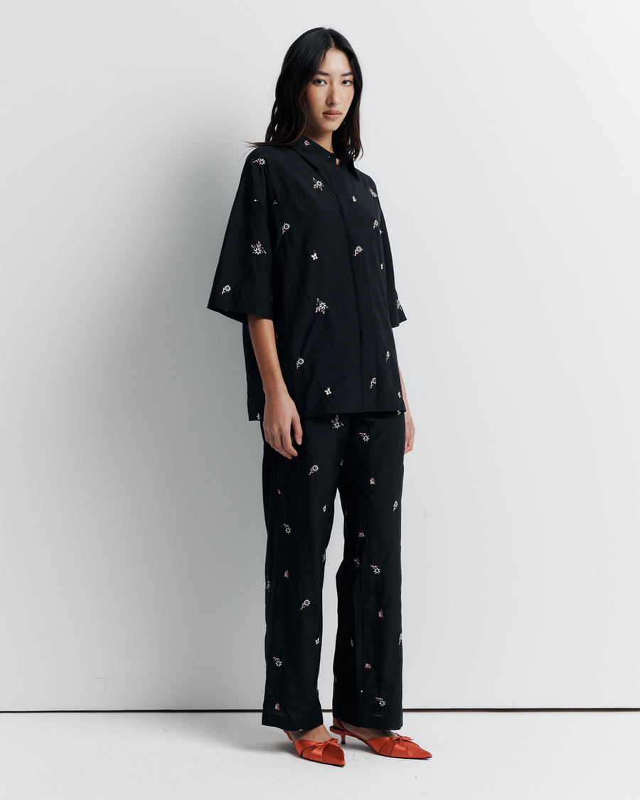 The June Shirt is an oversized short sleeve button-up featuring a concealed placket, exaggerated sleeves, and delicate floral embroidery for a subtle romantic touch. Pair it with the matching pant or wear it open over a tank for easy styling. Shop now.