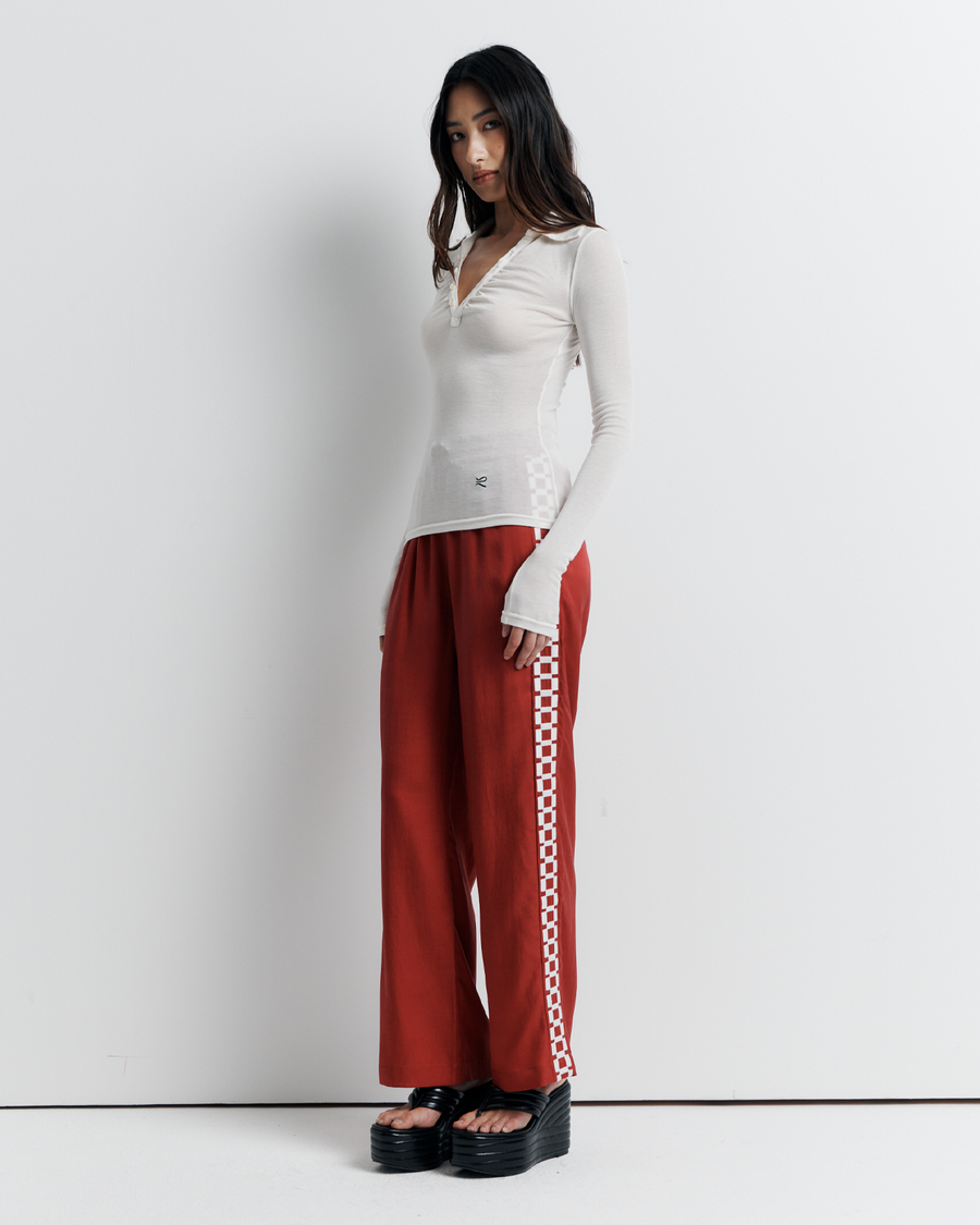 The Louise Knit Top in White is a collared Henley-style knit featuring soft bust gathers, elongated sleeves for layering, and signature ‘R’ embroidery—an effortlessly polished wardrobe essential.