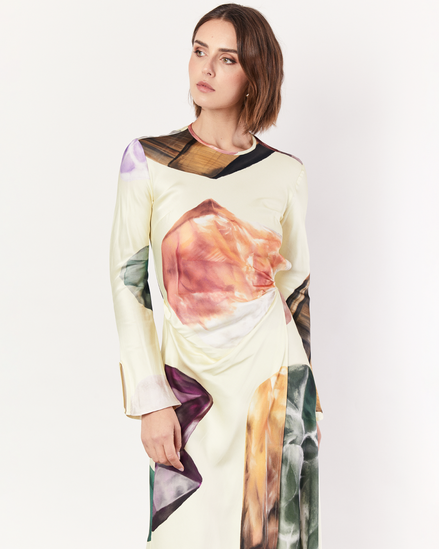 The Gemstone Wrap Dress boasts a fluid form and elevated style, featuring gathered detailing and a leg split. It is crafted from a silky recycled Oeko-Tex® certified viscose in the Gemstone Print, designed exclusively for Romy. Now available at Romy. 