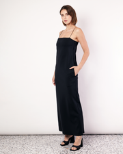 This floor-length bandeau dress is crafted from a luxurious stretch scuba fabrication, featuring rouleau shoulder straps and an inner shelf bra. With side pockets and a classic and elegant silhouette, this will soon become your go-to black dress. Now available at Romy. 