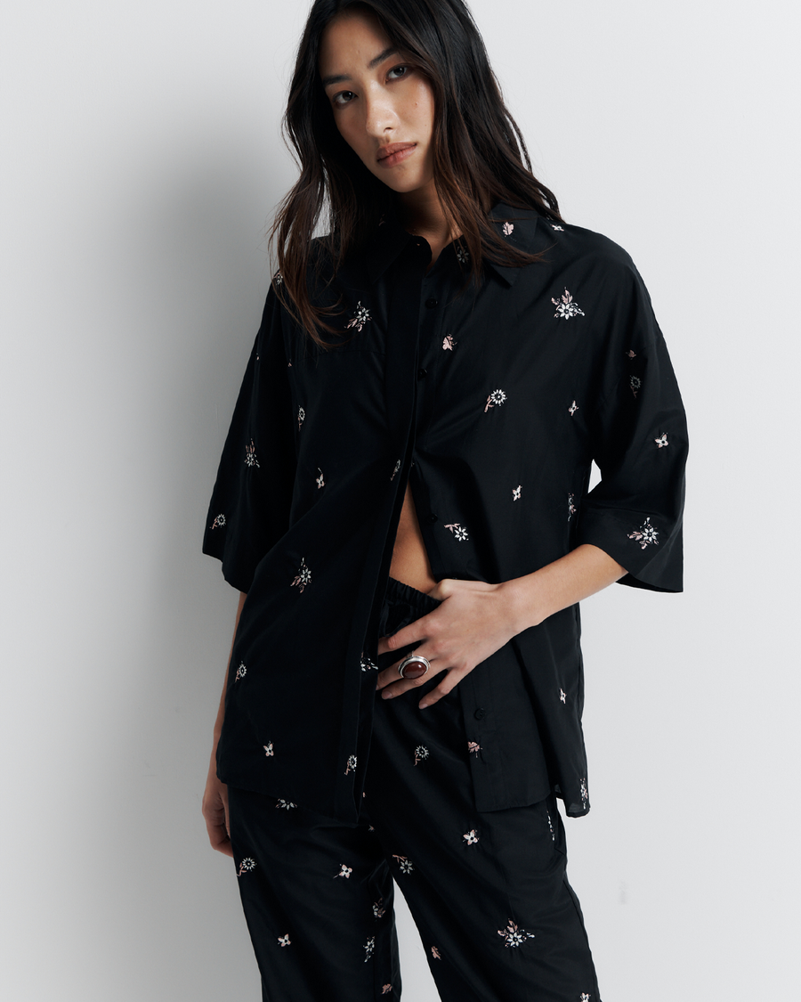 The June Shirt is an oversized short sleeve button-up featuring a concealed placket, exaggerated sleeves, and delicate floral embroidery for a subtle romantic touch. Pair it with the matching pant or wear it open over a tank for easy styling. Shop now.