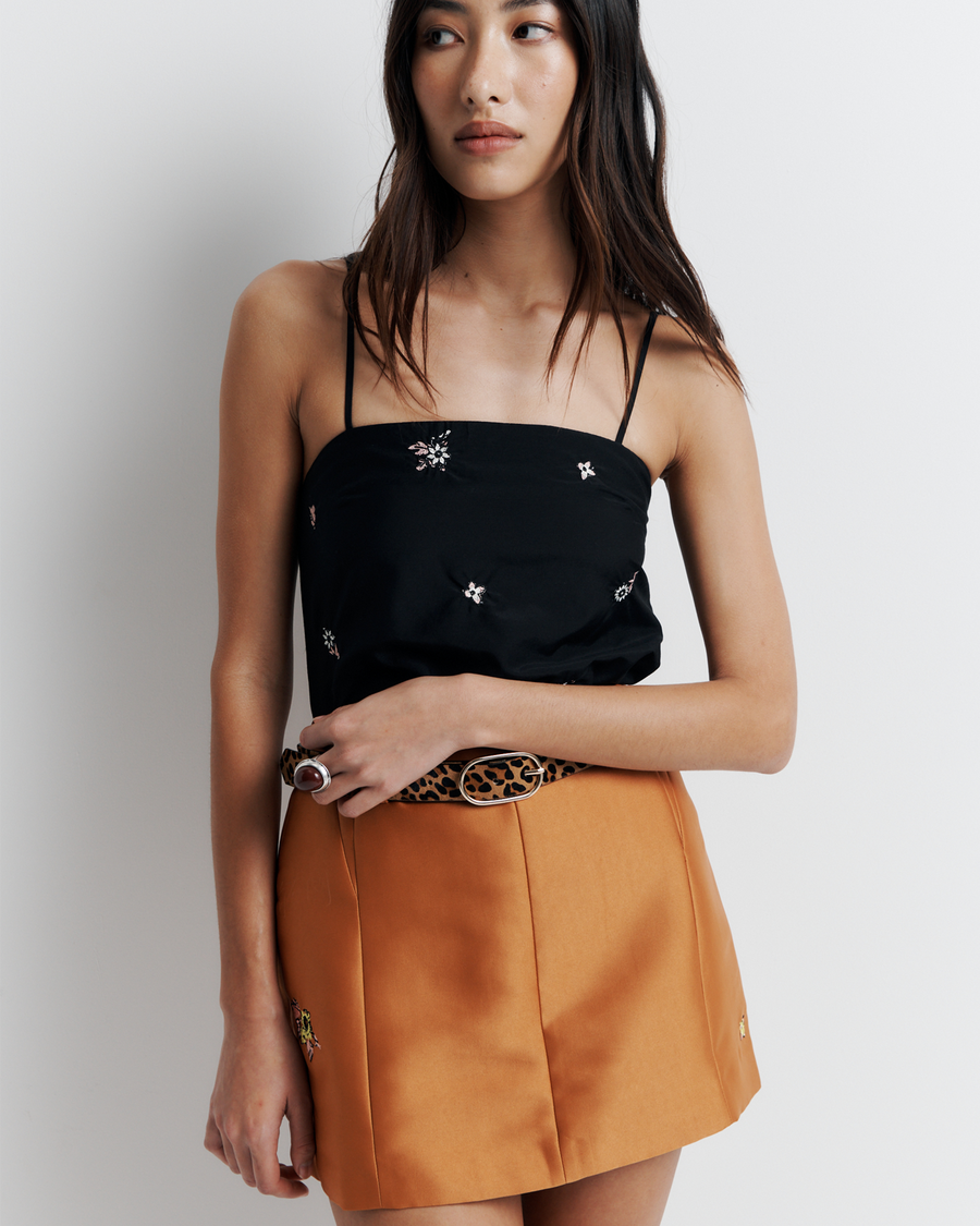 The Jade Skirt is a mini style with belt loops and contouring panel lines for a flattering, curve-enhancing fit—finished with delicate floral embroidery for a subtle romantic touch.