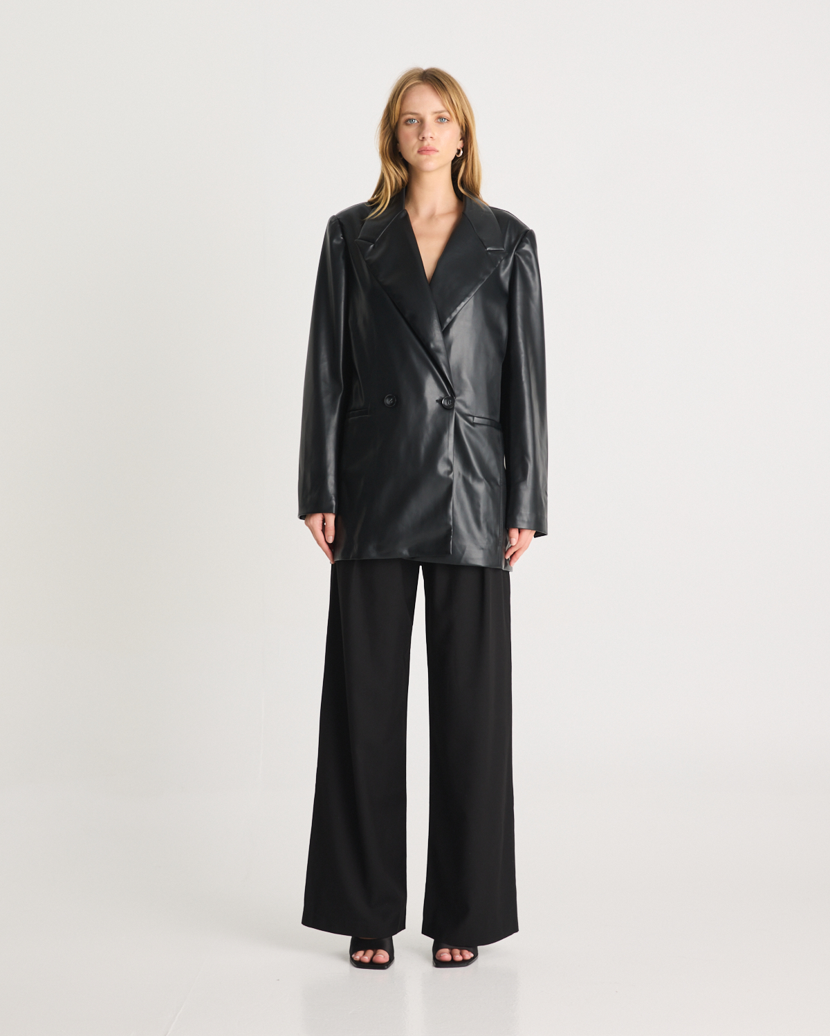 The Vegan Leather Boxy Blazer is a relaxed, oversized silhouette, featuring front pockets and a button closure. It is fully lined and is crafted from a buttery soft Vegan leather fabrication in Black. Now available at Romy. 