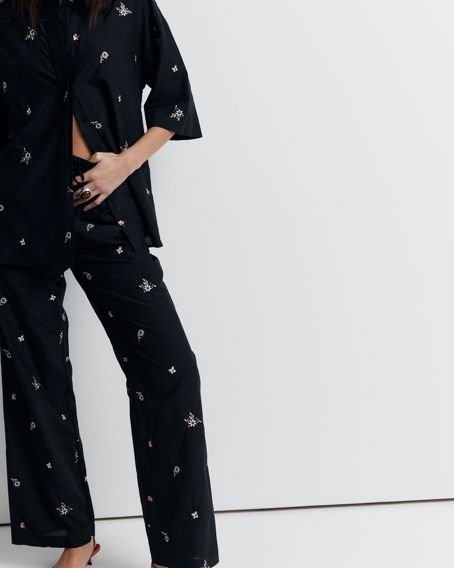 The June Shirt is an oversized short sleeve button-up featuring a concealed placket, exaggerated sleeves, and delicate floral embroidery for a subtle romantic touch. Pair it with the matching pant or wear it open over a tank for easy styling. Shop now.
