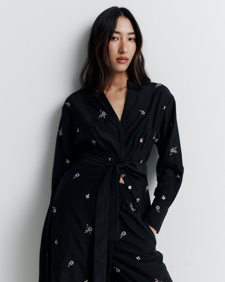 The Lola Shirt Dress is a lightweight, button-through shirtdress featuring pleated waist detailing, a removable belt, and delicate floral embroidery for a romantic, feminine finish.