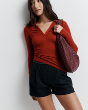 The Louise Knit Top in Red is a collared Henley-style knit featuring soft bust gathers, elongated sleeves for layering, and signature ‘R’ embroidery—an effortlessly polished wardrobe essential.