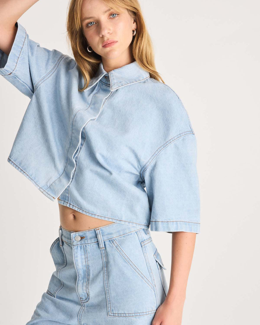 This Denim Shirt is a take on a Romy Classic in a light blue wash in a 100% cotton. It an elevated take on your staple denim shirt that can be styled fastened or open over any dress or tank. Shop now.