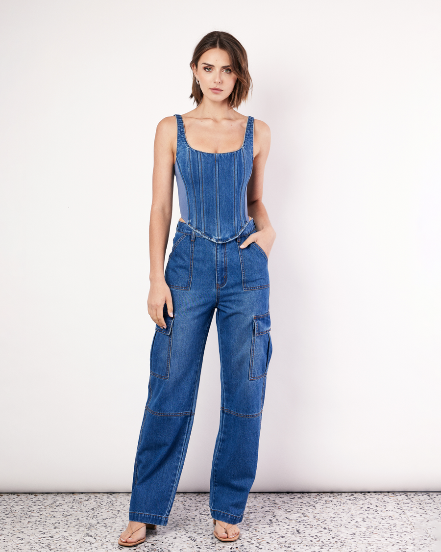 The Denim Bustier is a structured top, featuring adjustable straps, boning detail through the front, a zip closure and dipped waist to flatter your waistline. The side panels are made from scuba fabric that mould to the body and hug you in. Now available at Romy.