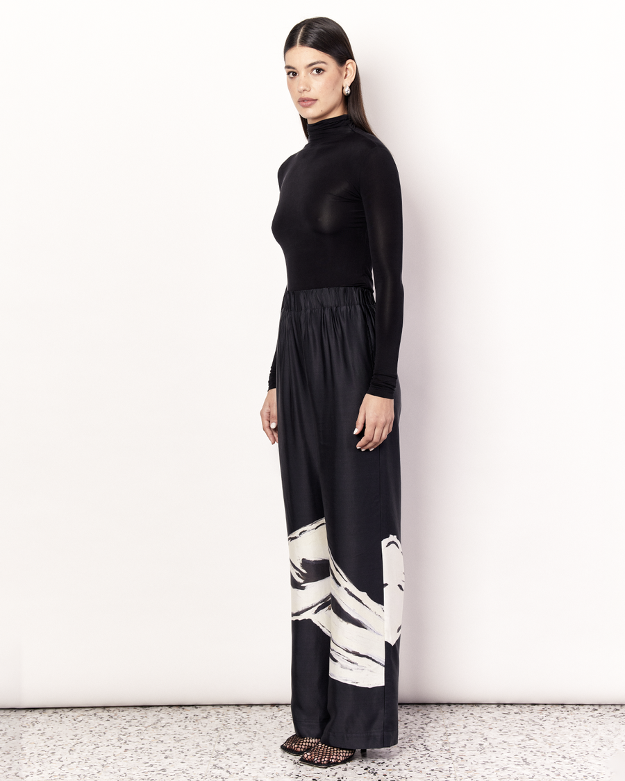 The Hip Hills Pant features an elastic waistband and side pockets in our signature relaxed straight leg pant silhouette, offering an elevated yet comfortable style. It is crafted from a silky recycled Oeko-Tex® certified viscose in the Hip Hills Print, designed in collaboration with Tasmanian artist, Shelley Bickerstaff, in Black and White. Now available at Romy. 